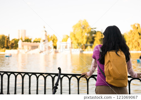 Peruvian student enjoys the view of the lake and the monument to alfonso xii in retiro park, madrid Peruvian student enjoys the view of the lake and the monument to alfonso xii in retiro park, madrid 121069067
