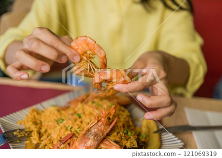 Arroz marinero Ecuadorian cuisine, traditional food, rice recipe with seafood. Hands closeup eating Arroz marinero Ecuadorian cuisine, traditional food, rice recipe with seafood. Hands closeup eating 121069319