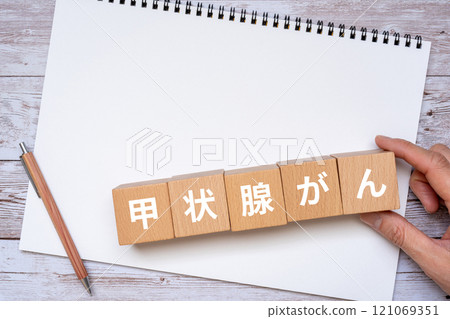 Thyroid cancer written on block, notebook and hand 121069351