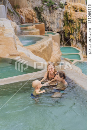Mother with her toddler and teenage sons bathing in the hot springs of Grutas Tolantongo, Mexico. Family adventure, relaxation, and natural wellness concept Mother with her toddler and teenage sons bathing in the hot springs of Grutas Tolantongo, Mexico. Family adventure, relaxation, and natural wellness concept 121069356