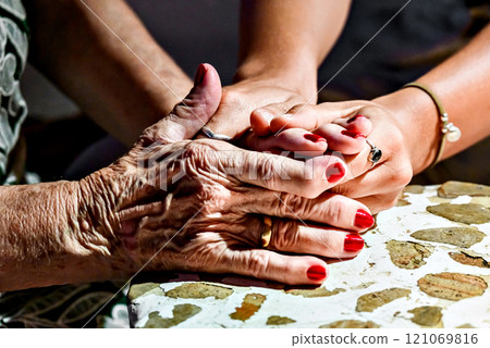Affection and tenderness of a granddaughter to her grandmother. Traits of aging on the hands 121069816