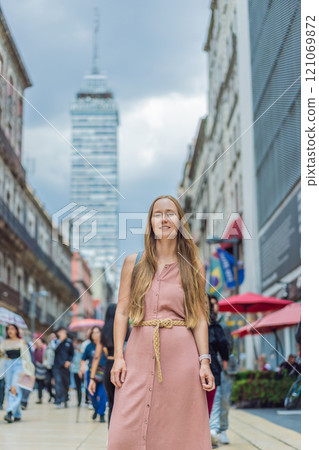 Female tourist exploring Latin American Tower in Mexico City. Iconic skyscraper, historic architecture, and urban exploration concept Female tourist exploring Latin American Tower in Mexico City. Iconic skyscraper, historic architecture, and urban exploration concept 121069872