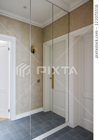 A Stylish Modern Hallway featuring Beautiful Mirrored Accent Walls and Elegant Lighting Solutions A Stylish Modern Hallway featuring Beautiful Mirrored Accent Walls and Elegant Lighting Solutions 121070316