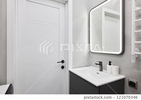 Experience a Modern Bathroom Interior that Features a Sleek Design Alongside a Mirror 121070346