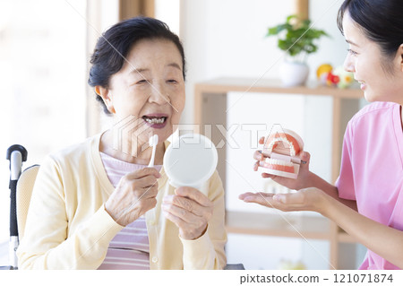 老年婦女接受牙科保健員的刷牙指導 121071874