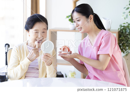 老年婦女接受牙科保健員的刷牙指導 121071875
