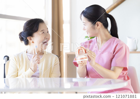 老年婦女接受牙科保健員的刷牙指導 老年婦女接受牙科保健員的刷牙指導 121071881