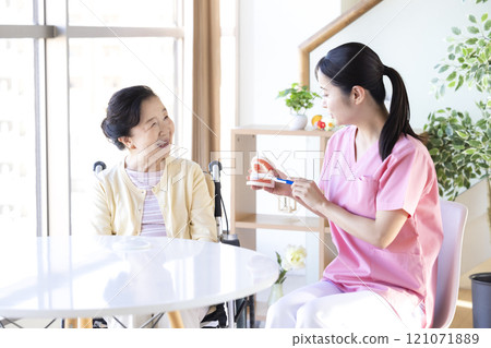 老年婦女接受牙科保健員的刷牙指導 老年婦女接受牙科保健員的刷牙指導 121071889