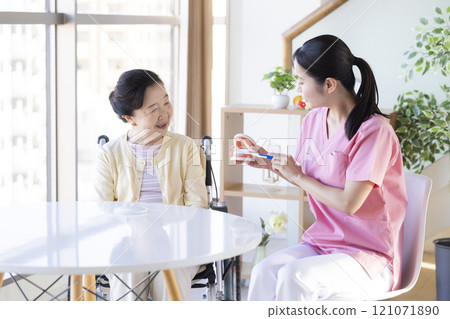 Senior woman receiving tooth brushing instruction from dental hygienist Senior woman receiving tooth brushing instruction from dental hygienist 121071890