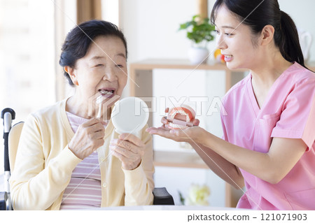 老年婦女接受牙科保健員的刷牙指導 121071903