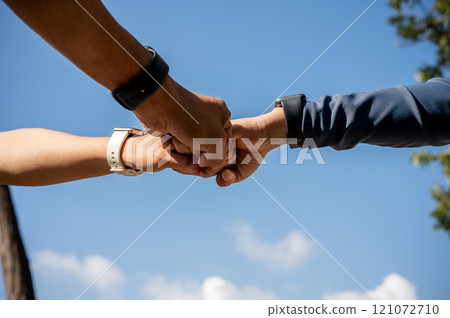 A group of sporty individuals in sportswear and smartwatches giving each other a fist bump. A group of sporty individuals in sportswear and smartwatches giving each other a fist bump. 121072710