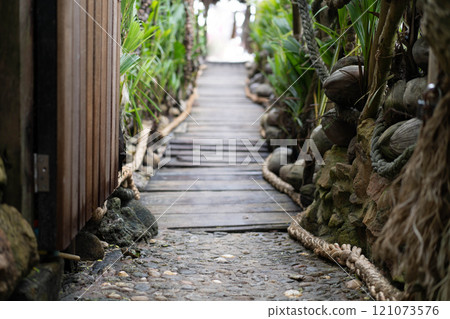 A podium for your text or product. The focus is in front and in the background there is a path with tropical plants leading to the sea. 121073576