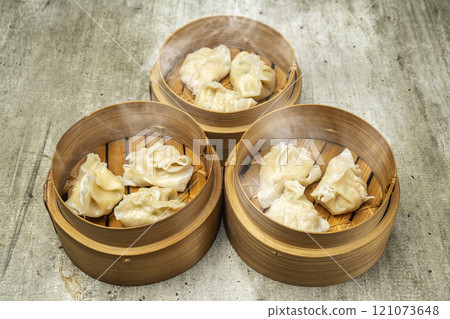 Assorted chinese dim sum dumpling on bamboo wooden basket bowl on wooden table Assorted chinese dim sum dumpling on bamboo wooden basket bowl on wooden table 121073648