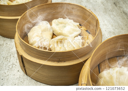 Assorted chinese dim sum dumpling on bamboo wooden basket bowl on wooden table Assorted chinese dim sum dumpling on bamboo wooden basket bowl on wooden table 121073652