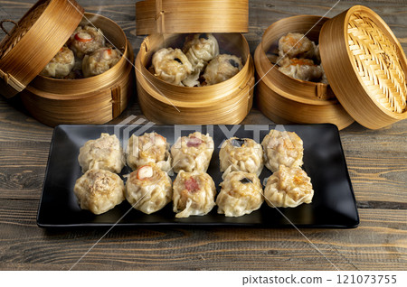 Assorted chinese dim sum dumpling on the plate with bamboo wooden basket bowl on wooden table Assorted chinese dim sum dumpling on the plate with bamboo wooden basket bowl on wooden table 121073755