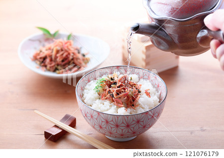 Pouring tea over dried baby rice 121076179