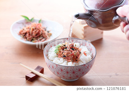 Pouring tea over dried baby rice 121076181