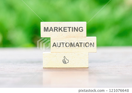 Marketing automation blocks placed prominently on a table against a blurred green background 121076648