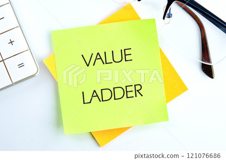 Business concept. The text of the Business concept. Text VALUE LADDER close-up, top view on a light green sticker 121076686