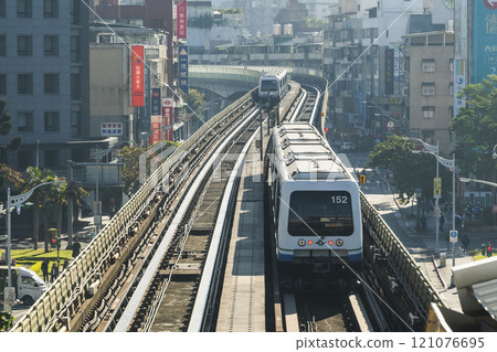 View of a Wenhu or Brown line train running on the elevated track of the Taipei Mass Rapid Transit System with the building background. 121076695