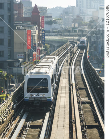 View of a Wenhu or Brown line train running on the elevated track of the Taipei Mass Rapid Transit System with the building background. 121076696