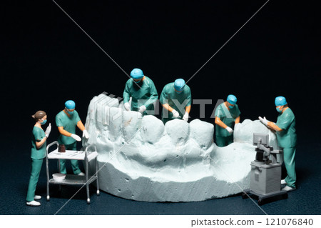 Miniature surgeons working on a dental model, showcasing the intricacies of dental procedures in a unique and artistic manner 121076840