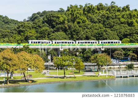 A train traveling on the Wenhu or Brown Line of the Taipei MRT, Taiwan, passes by Taipei Dahu Park. 121076883