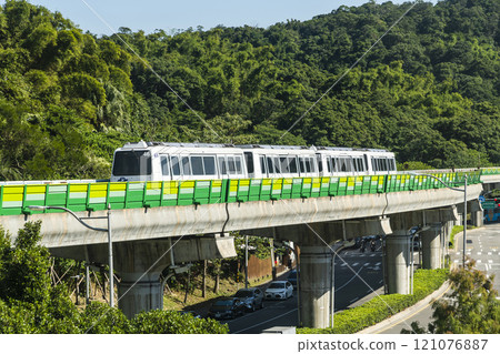 A train traveling on the Wenhu or Brown Line of the Taipei MRT, Taiwan, passes by Taipei Dahu Park. 121076887