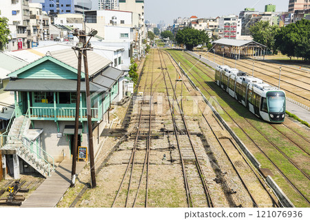 The circular light rail train drives past the former Kaohsiung Port Station North Signal Box, Taiwan. 121076936