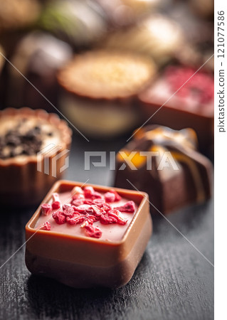 Mix of chocolate pralines on black table. Mix of chocolate pralines on black table. 121077586