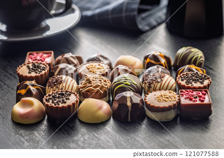 Mix of chocolate pralines on black table. 121077588