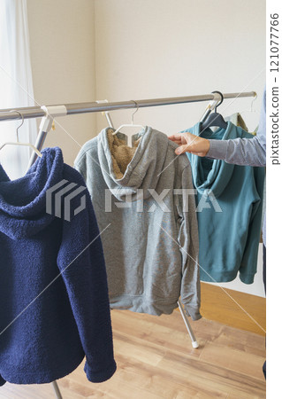 男人拿起一件連帽衫 121077766