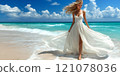 A beautiful female tourist in a light white dress walks along the beach. 121078036
