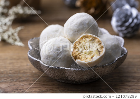 Snowball cookies served in a silver dish on a table 121078289