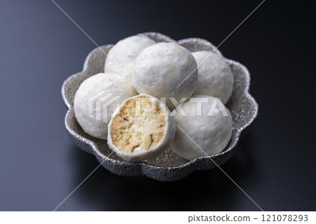 Silver dish and snowball cookies stand out against a black background Silver dish and snowball cookies stand out against a black background 121078293