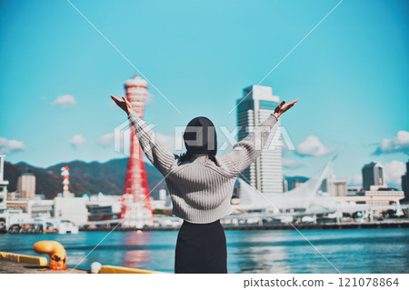 Kobe cityscape and the back view of a woman raising her arms in the air Kobe cityscape and the back view of a woman raising her arms in the air 121078864