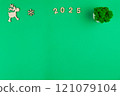 Spread on a green background chroma key on top of the photo there is a wooden deer with branchy antlers, a green office flower made of moss in a white pot, a wooden snowflake, 2025 inscription in 121079104