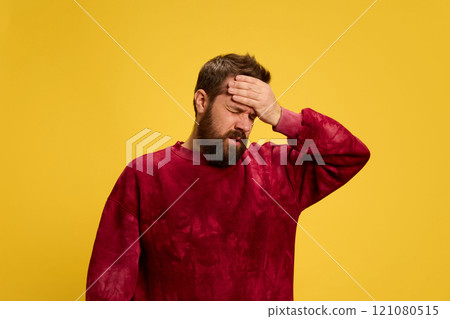 Portrait of man dressed casually putting hand on head as he felt fever against bright yellow background. Viruses and symptoms. Portrait of man dressed casually putting hand on head as he felt fever against bright yellow background. Viruses and symptoms. 121080515