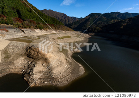 The bottom of Egenji Dam with the water level reduced and a distant view of the Suzuka mountain range 121080978