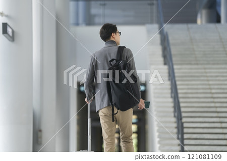 A man in his 40s walking with a carry bag, back view A man in his 40s walking with a carry bag, back view 121081109