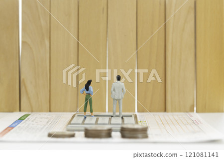 報稅表 年收入牆 金錢圖像 站在報稅表和計算器上的一男一女的數字 121081141