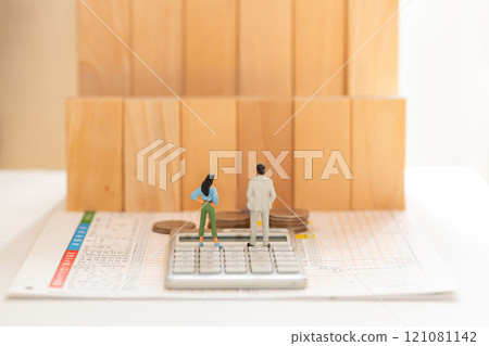 報稅表 年收入牆 金錢圖像 站在報稅表和計算器上的一男一女的數字 121081142