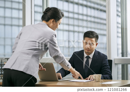 asian business manager reviewing report in office 121081266