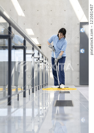 Image of building cleaning: A middle-aged female cleaning staff mopping the floor Image of building cleaning: A middle-aged female cleaning staff mopping the floor 121081487