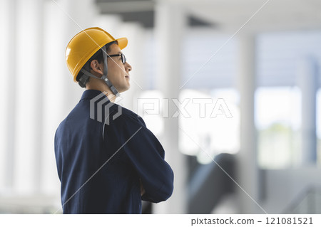 一名 40 多歲男子穿著工作服、戴著頭盔的側面影像 121081521