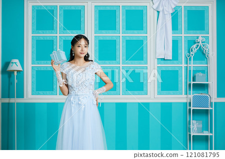 Portrait of a young woman in a dress photographed against an antique background 121081795