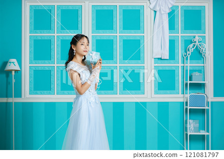 穿著裙子的年輕女子在古董背景下拍攝的肖像 121081797