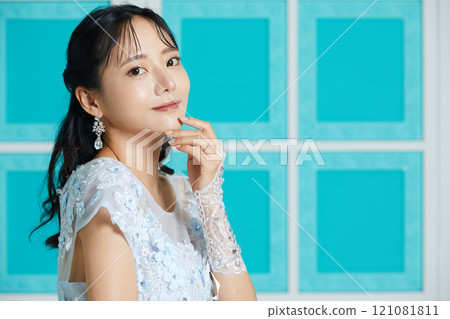 Portrait of a young woman in a dress photographed against an antique background 121081811
