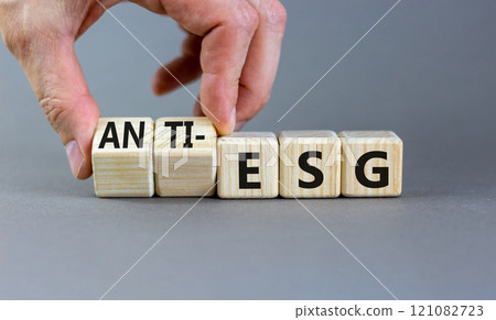 Anti-ESG environment social governance symbol. Concept word Anti-ESG on wooden cubes. Businessman hand. Beautiful grey background. Business Anti-ESG environment social governance concept. Copy space. 121082723