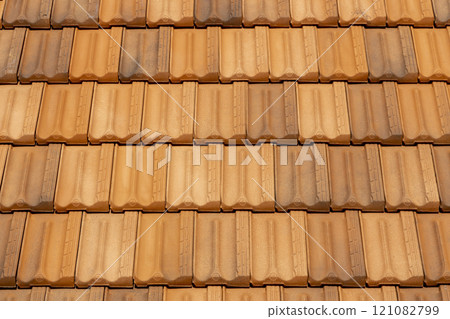 Old tile roof above the house and hard shadows from sunny in a summer day. Aerial top view from drone. Beautiful background. Old tile roof above the house and hard shadows from sunny in a summer day. Aerial top view from drone. Beautiful background. 121082799